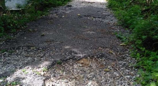 Kondisi Jalan EK Fangidae yang rusak, aspalnya sudah terlepas akibat tergerus air sehingga menyebabkan lubang. (foto: istimewa)