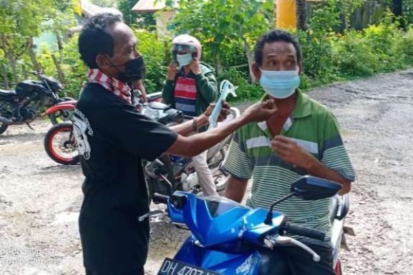 Salah seorang pengendara motor yang kebagian masker gratis dari pemuda lintas kelurahan. (foto: istimewa)
