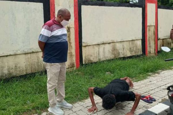 Lurah Pasir Panjang, Ferdinan Masae langsung memberi sangsi push up terhadap salah satu warga yang kedapatan tidak mengenakan masker saat melintasi wilayahnya. (foto: andi/kupangterkini.com)