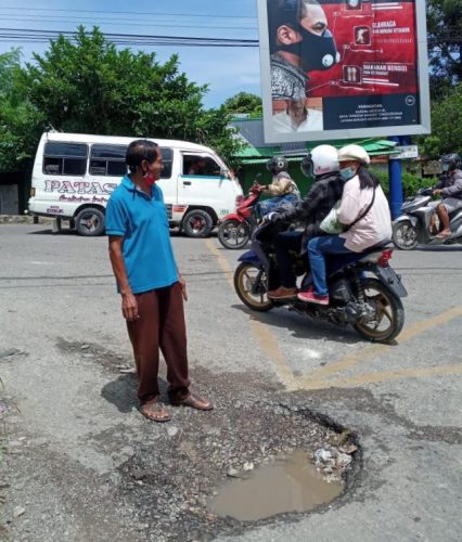 Jalan berlubang dan membahayakan pengendara persis di depan kantor Lurah Oepura, Jalan Amabi. (ist)