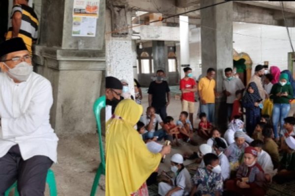 Muhammad Ansor di tempat khitanan Masjid Al-Fatah, Kampung Solor dan anak anak yang menunggu giliran untuk dikhitan. (yandry/kupangterkini.com)