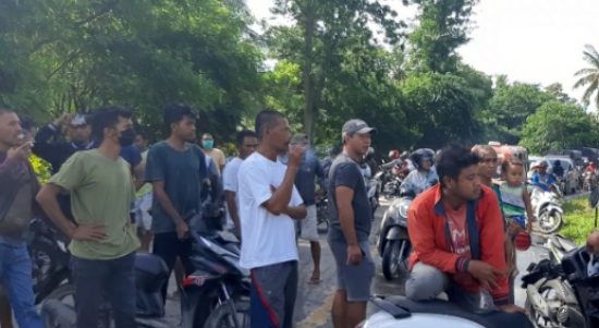 Warga kelurahan Babau memblokir Jalan Timor Raya dan menunggu pejabat pemerintah datang dan membantu memberikan makanan.