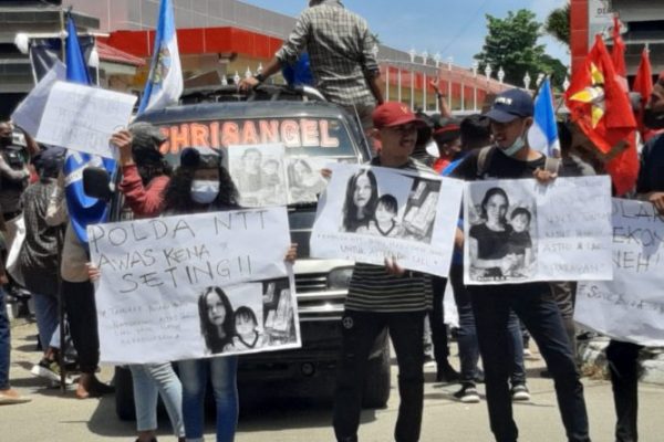 Massa aksi damai saat mendatangi Polda NTT memegang poster Astrid dan Lael serta dan tulisan sindiran bagi Polda NTT. (yandry/kupangterkini.com)