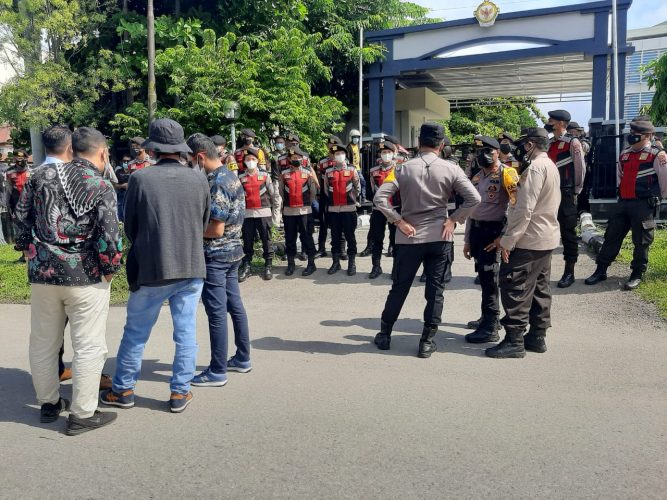 Petugas dari Polda NTT melakukan pagar betis halaman kantor Badan Pemeriksa Keuangan Kupang untuk mengamankan jalannya reka ulang kasus pembunuhan (yandry/kupangterkini.com)