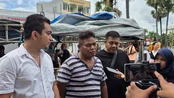 Imbo Tulung (kiri) mendampingi ayah kandung korban Delfi Foes ketika selesai otopsi