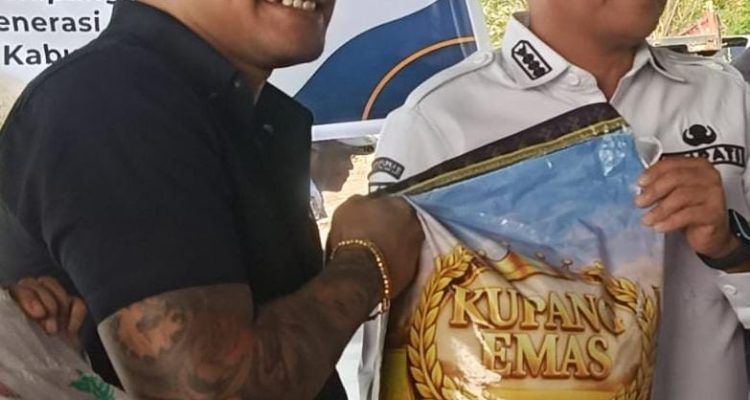 Piterson Lay mengangkat beras Kupang Emas hasil produksi CV SPM yang dikelolanya (yandry/kupangterkini.com)
